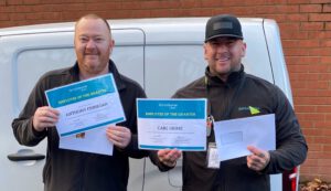 Two ServiceMaster employees holding Employee of the Quarter awards outside.