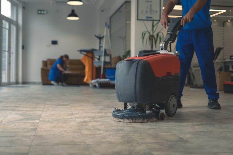 Professional floor cleaning with industrial scrubber in commercial space.