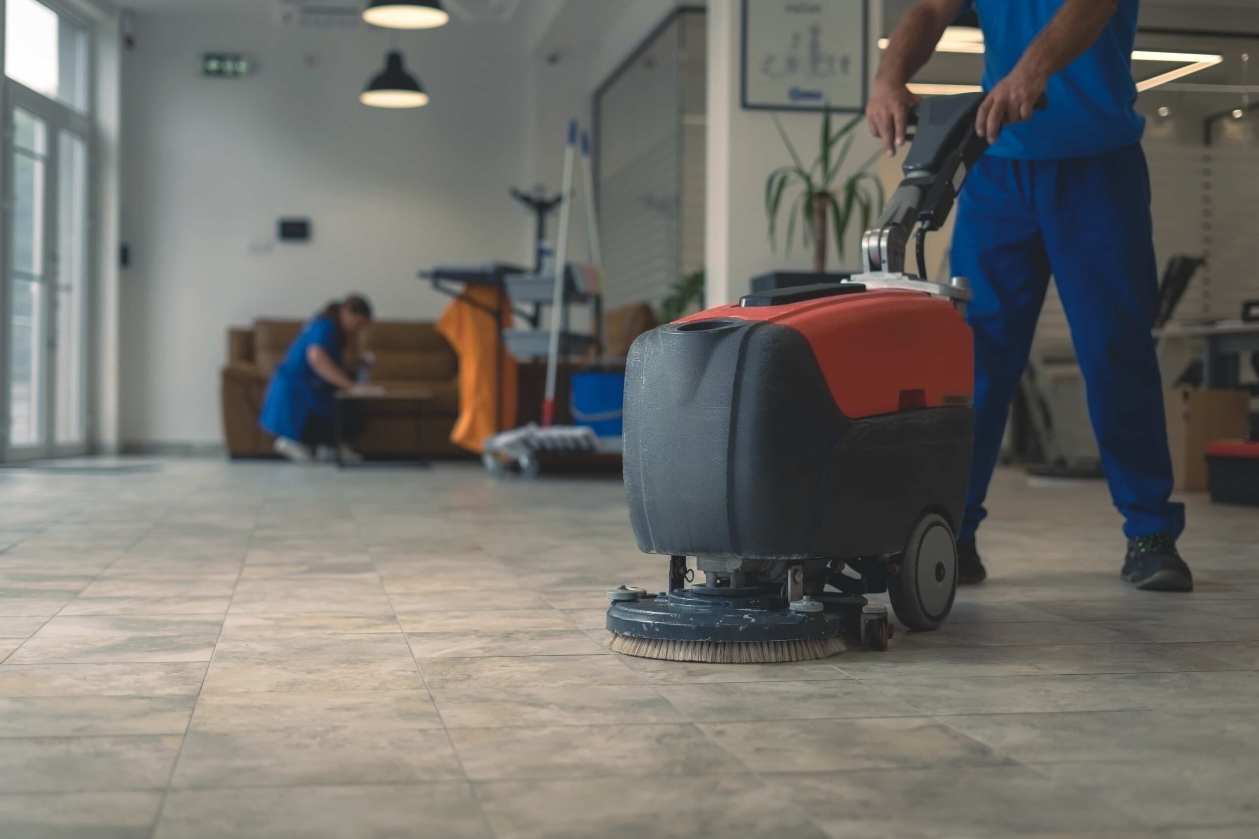 Professional floor cleaning with industrial scrubber in commercial space.
