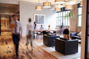 Modern office lounge with polished wooden floors and large windows, showcasing commercial floor clea.