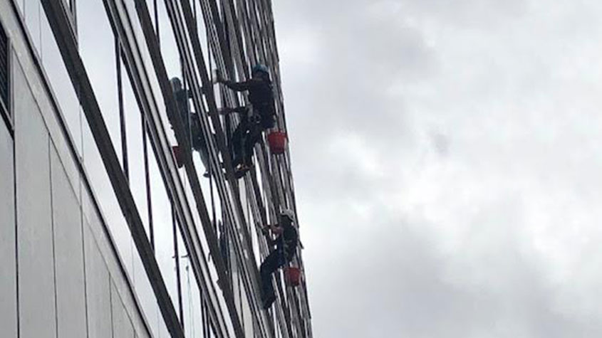 Professional commercial window cleaning on high-rise building in Manchester.