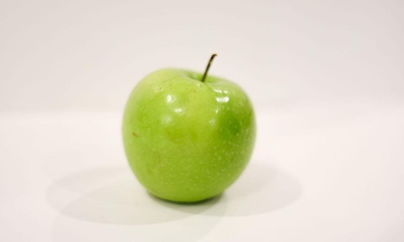 one green apple on a white background | Can Guinea Pigs Eat Apples?