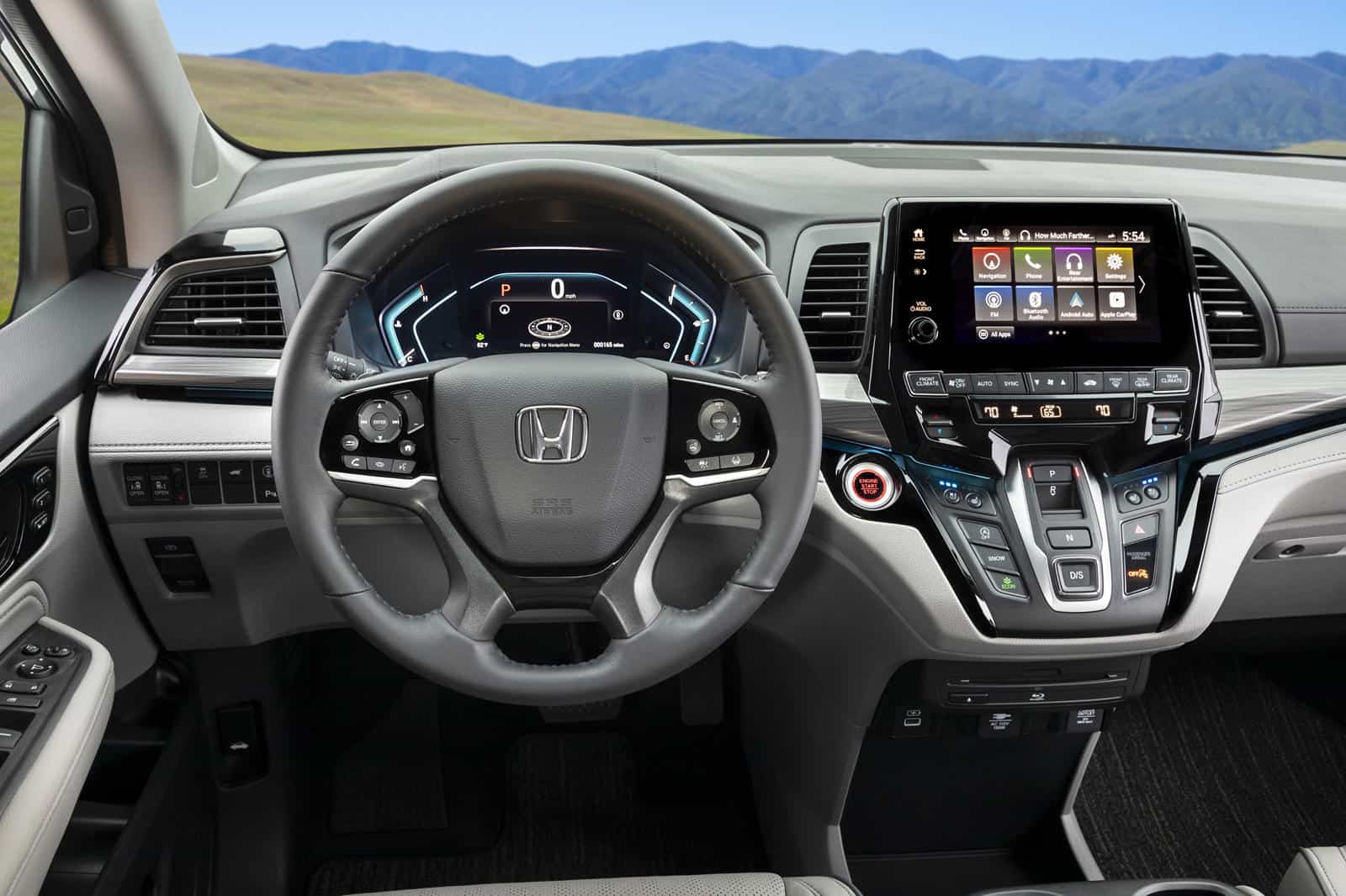 Interior dashboard of Honda Odyssey with advanced touchscreen display and steering wheel controls.