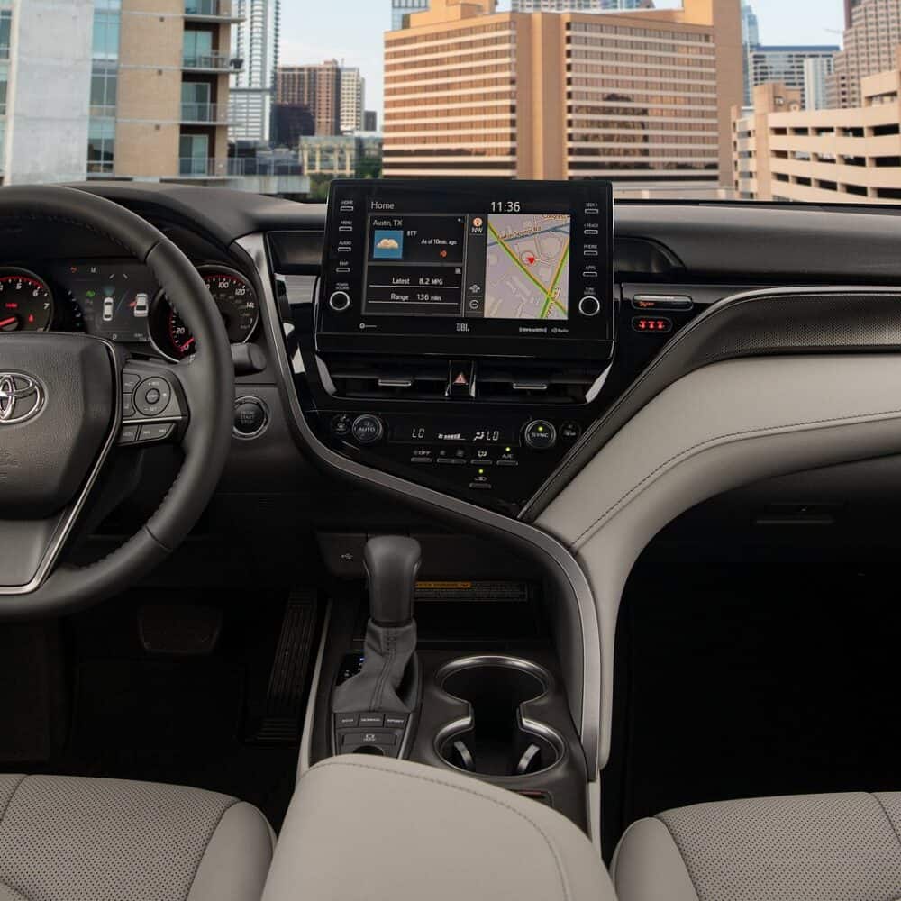 Interior dashboard of a Toyota Camry with modern touchscreen display and steering wheel controls.