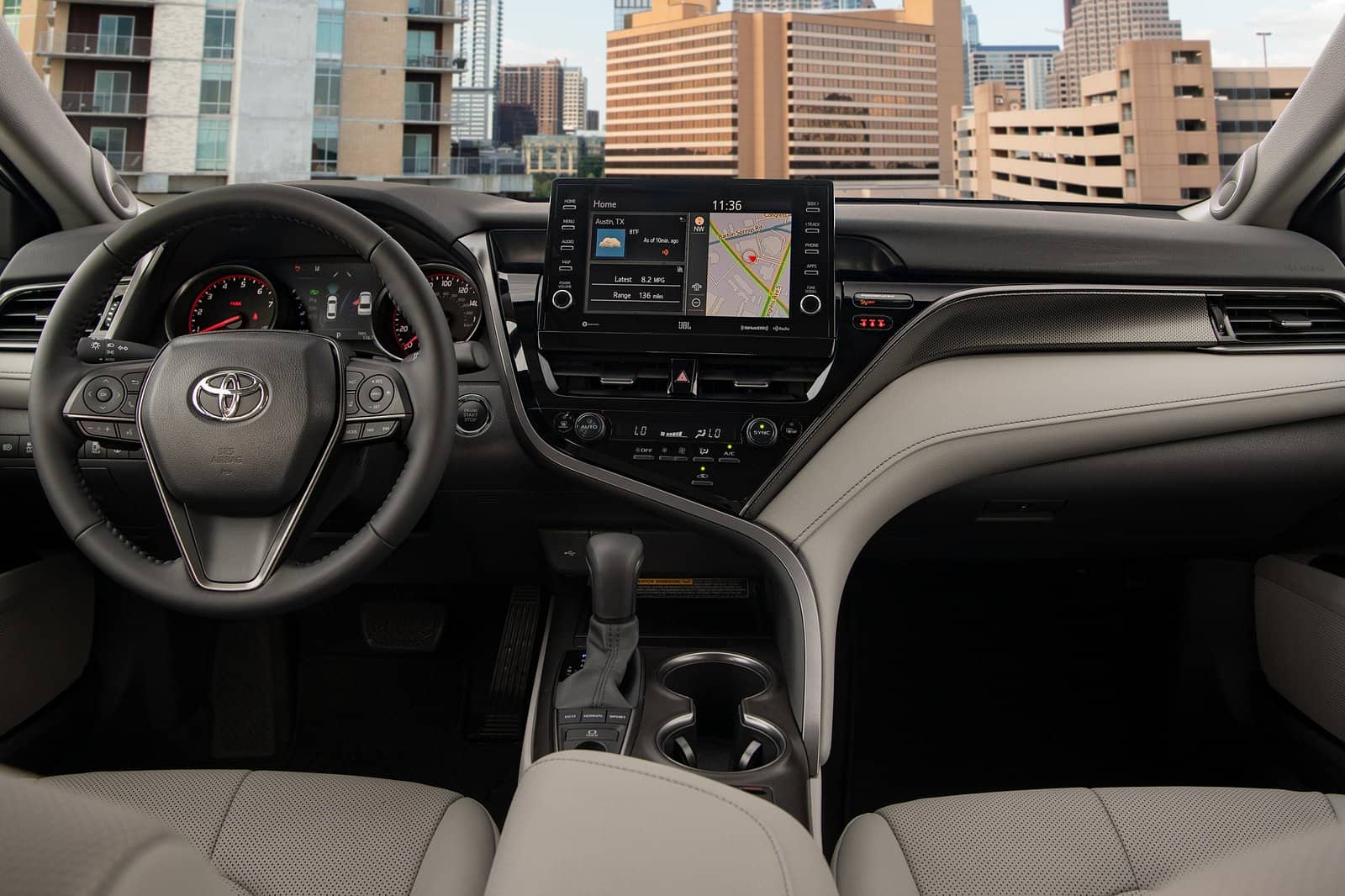 Interior dashboard of a Toyota Camry with modern touchscreen display and steering wheel controls.