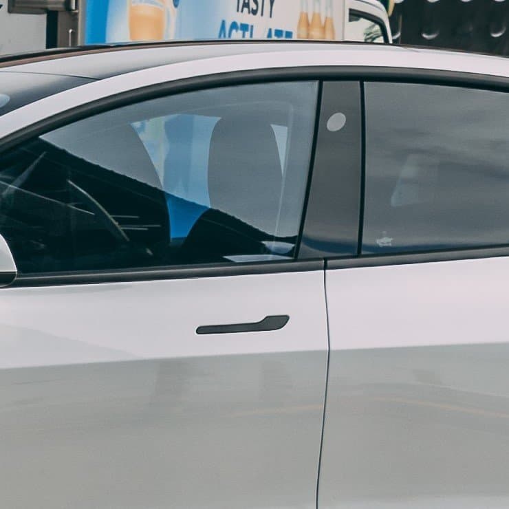 Modern Tesla Model 3 electric vehicle parked outdoors.