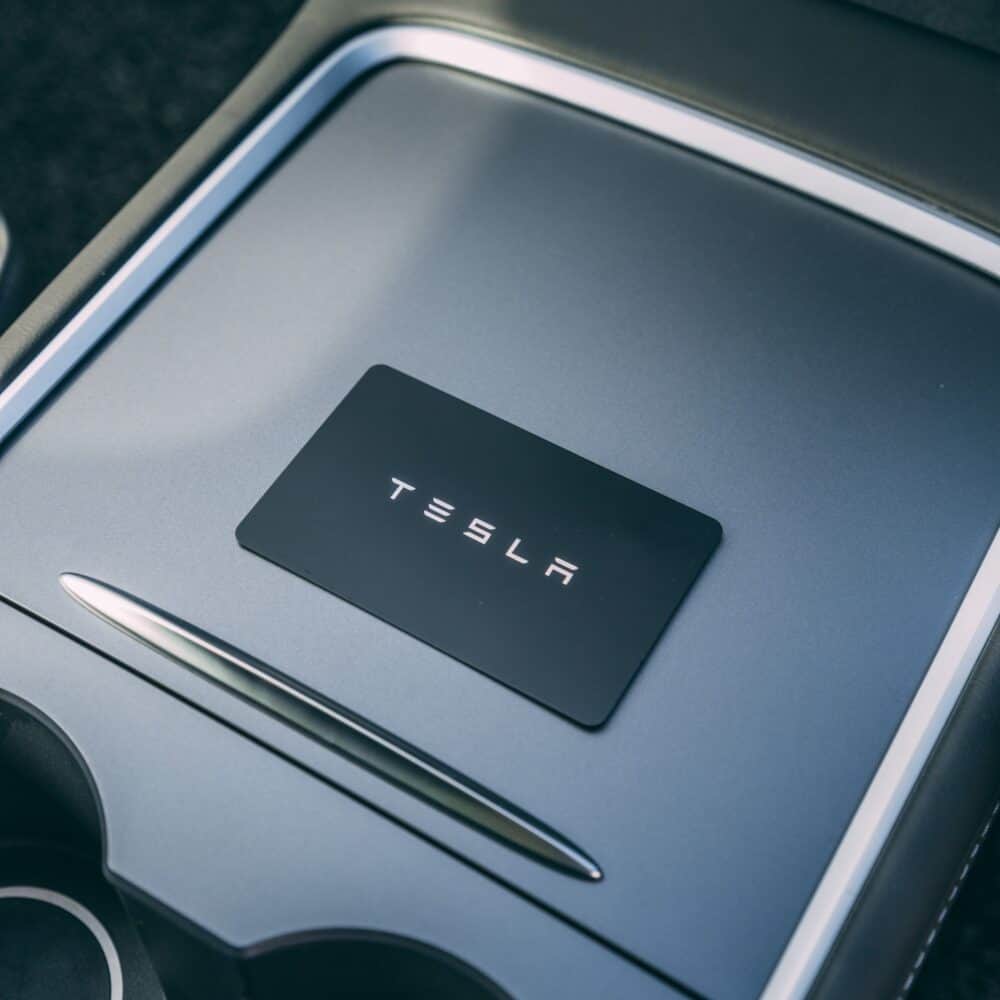 Tesla logo displayed on a sleek car dashboard.