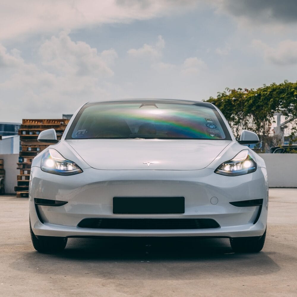 Modern Tesla Model 3 electric vehicle parked outdoors.