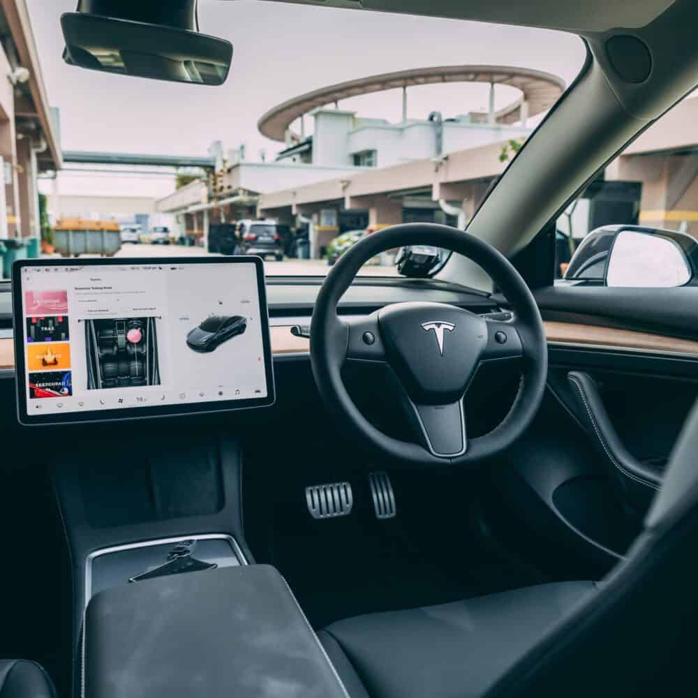 Tesla Model 3 car interior with touchscreen control panel and sleek design.