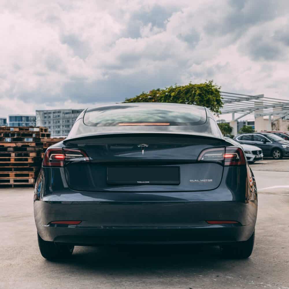 Tesla Model S electric vehicle parked outdoors with a modern urban background.