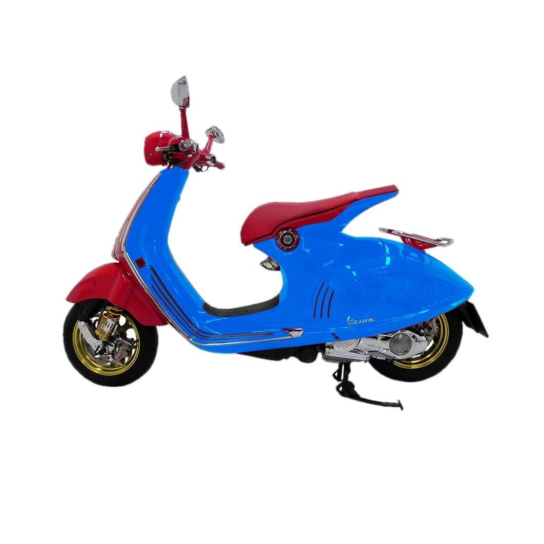 Vespa scooter with full protective film wrap in vibrant blue and red colors.