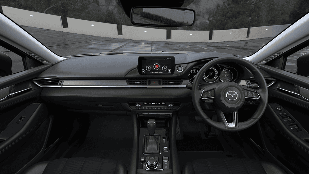 Interior dashboard and steering wheel of Mazda 6 with custom accessories.