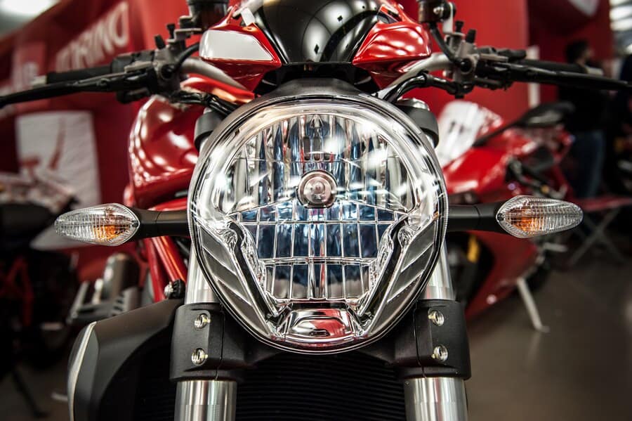 Motorcycle front headlight with detailed PPF installation for bike protection.