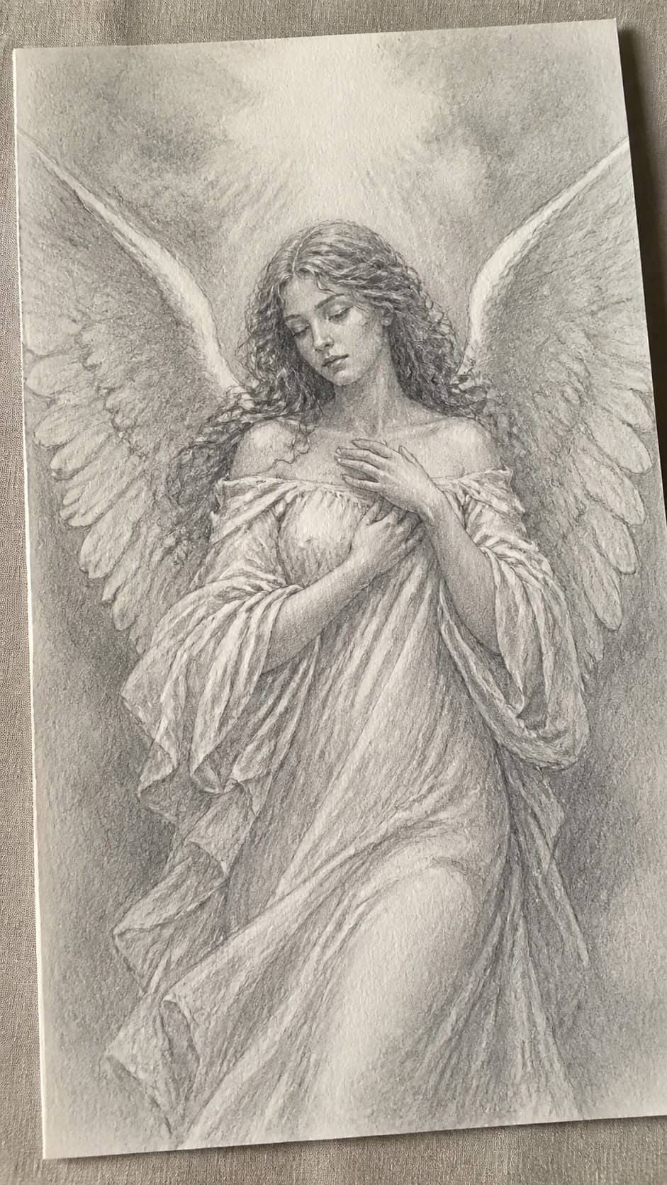 20 Girl Drawing Concepts to Elevate Your Art Game 23 Hand-drawn ethereal angel in graphite drawing on textured paper, shown in a gentle oblique desk view that shows paper tooth and — study 1