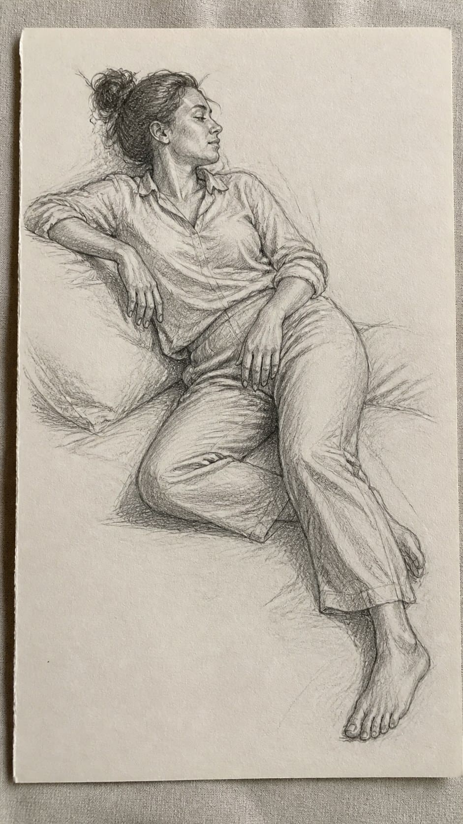 19 Creative Body Sketch Ideas Every Artist Should Try 38 Hand-drawn relaxed reclining pose in graphite drawing on textured paper, shown in a close overhead crop — study 2