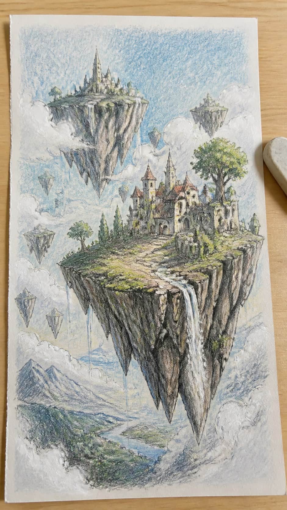 20 Challenging Drawing Ideas to Push Your Artistic Limits 44 Hand-drawn surreal landscape with floating islands in colored-pencil and gouache drawing on textured paper, shown in a close overhead — study 1