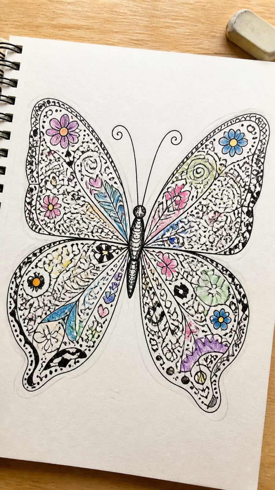 Bored of the Usual? Discover 16 Fresh Butterfly Drawing Concepts 23 Hand-drawn doodle butterfly in ink and colored-pencil drawing on textured paper, shown in a close overhead crop — study 2