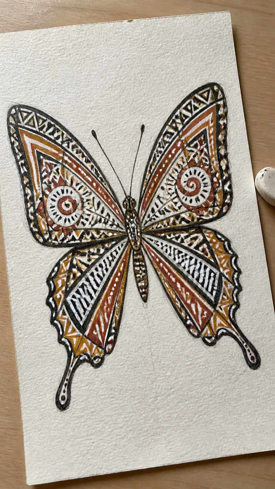 Bored of the Usual? Discover 16 Fresh Butterfly Drawing Concepts 28 Hand-drawn tribal pattern butterfly in colored-pencil and gouache drawing on textured paper, shown in a slightly off-center overhead — study 2