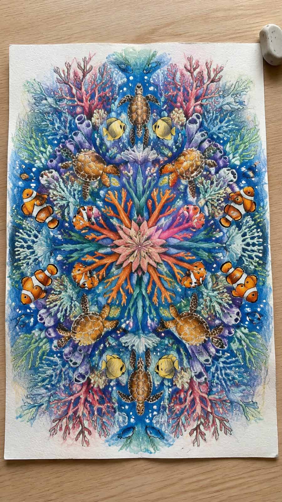 Hand-drawn coral reef kaleidoscope in colored-pencil and gouache drawing on textured paper, shown in a straight overhead view — study 2