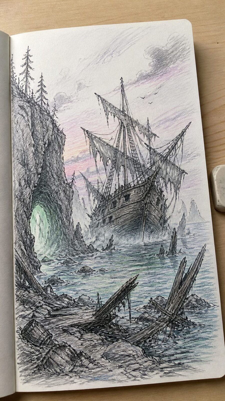 Hand-drawn spectral shipwreck shores in ink and colored-pencil drawing on textured paper, shown in a close overhead crop — study 2