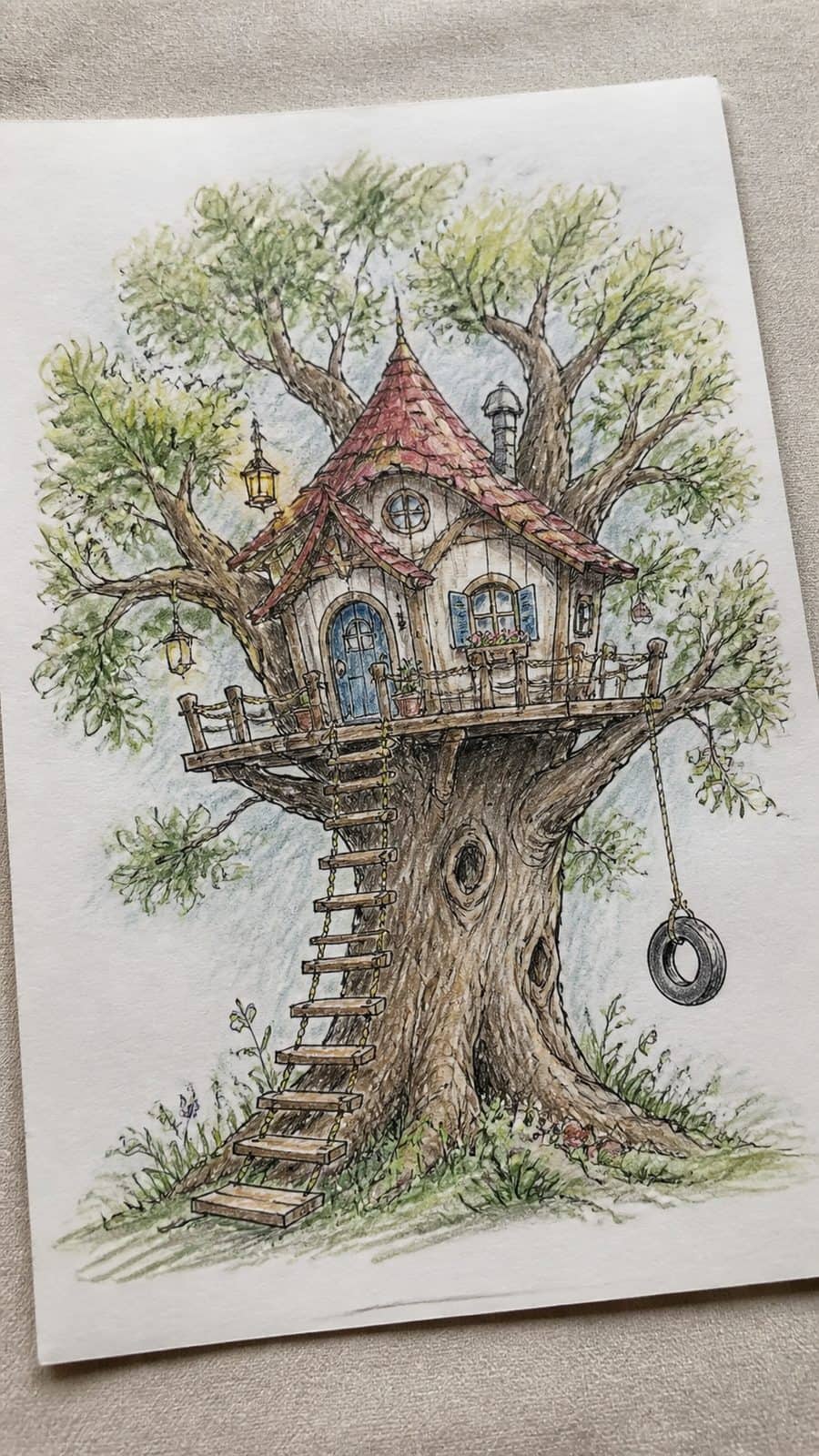 Explore 19 House Drawing Ideas That Blend Imagination with Reality 41 Hand-drawn storybook tree house in colored-pencil drawing on textured paper, shown in a gentle oblique desk view that shows paper — study 2