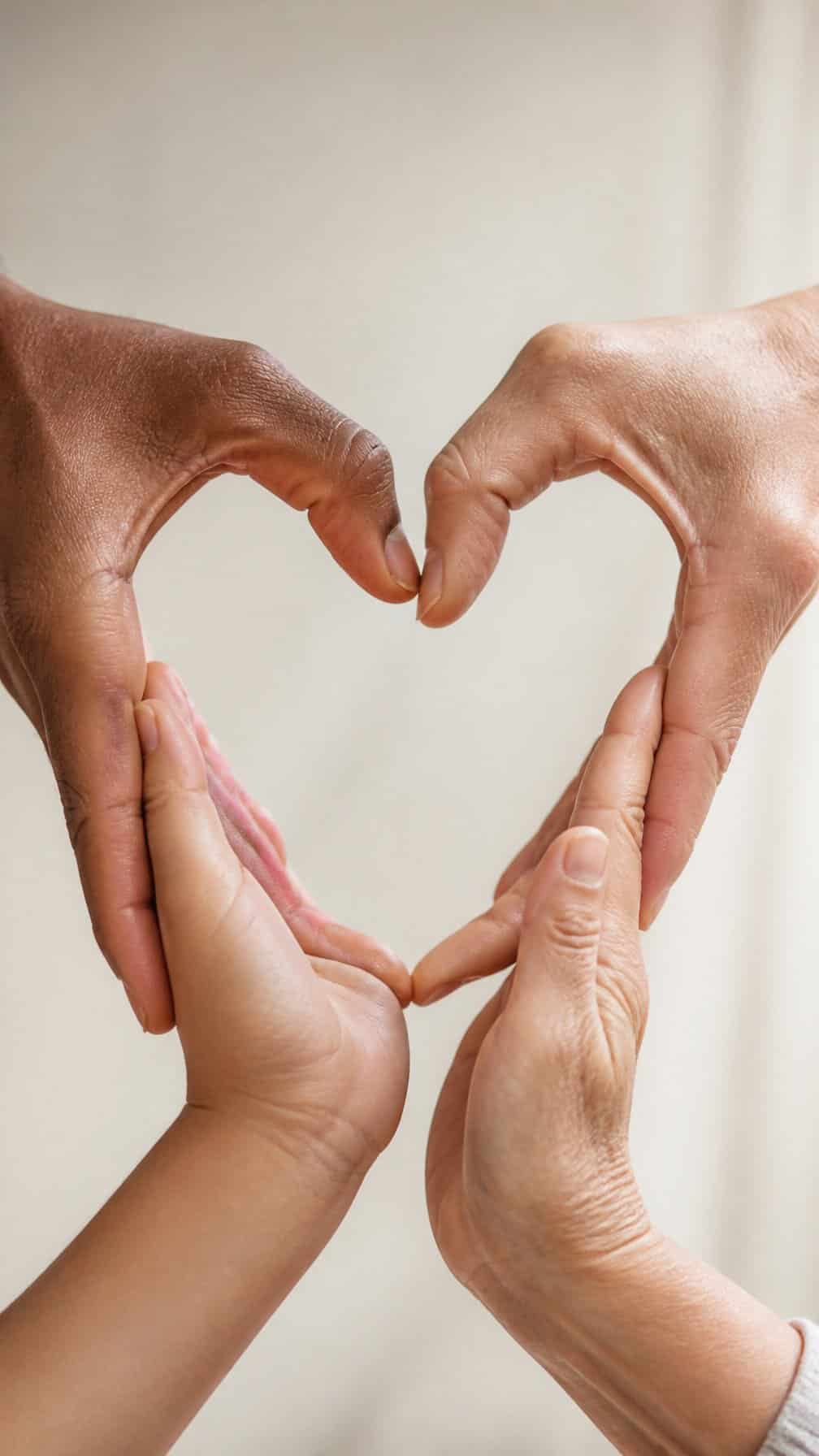 Family members’ hands come together to form a heart shape.