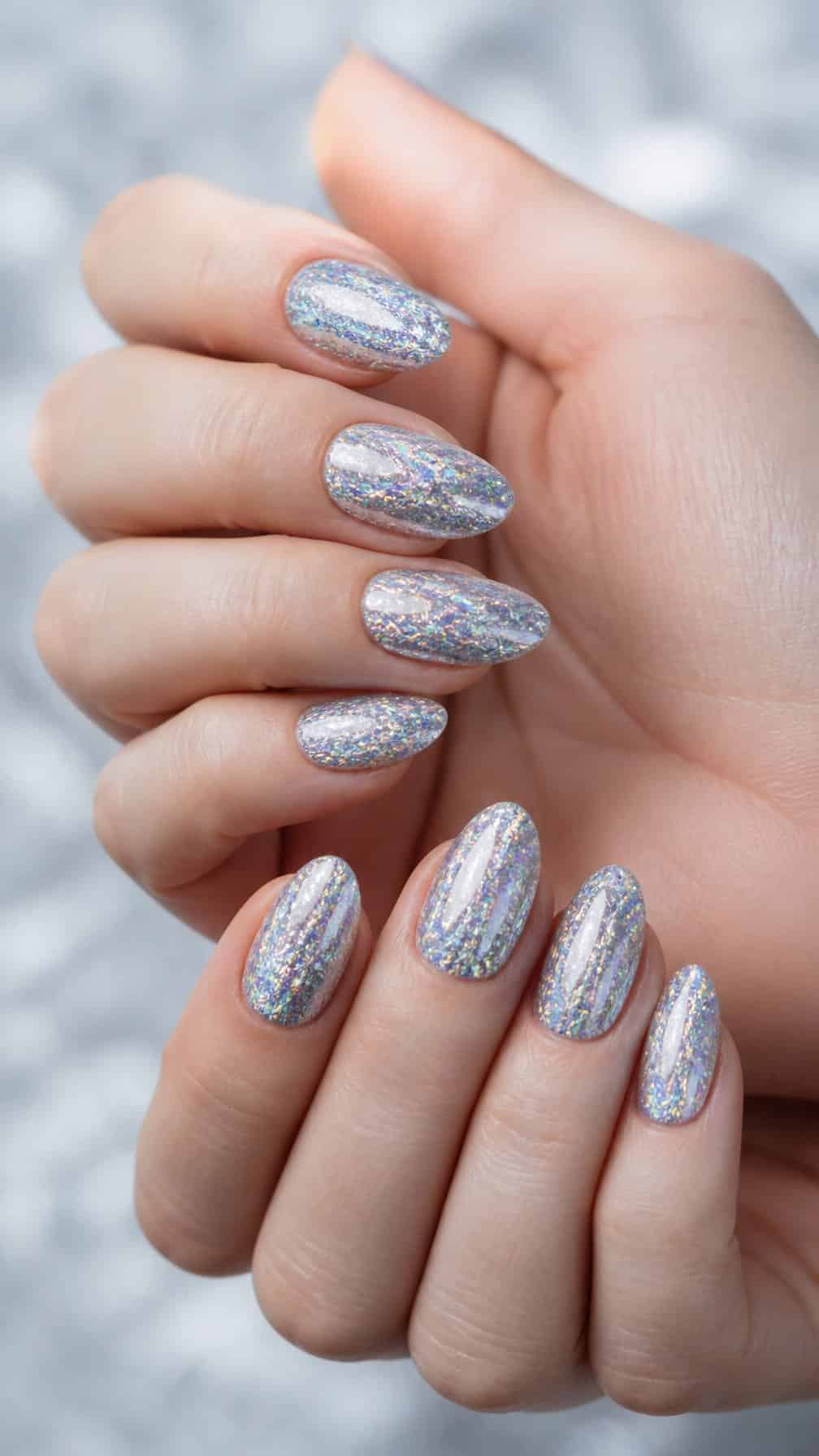 Close-up of hands with shimmering holographic silver glitter nails.