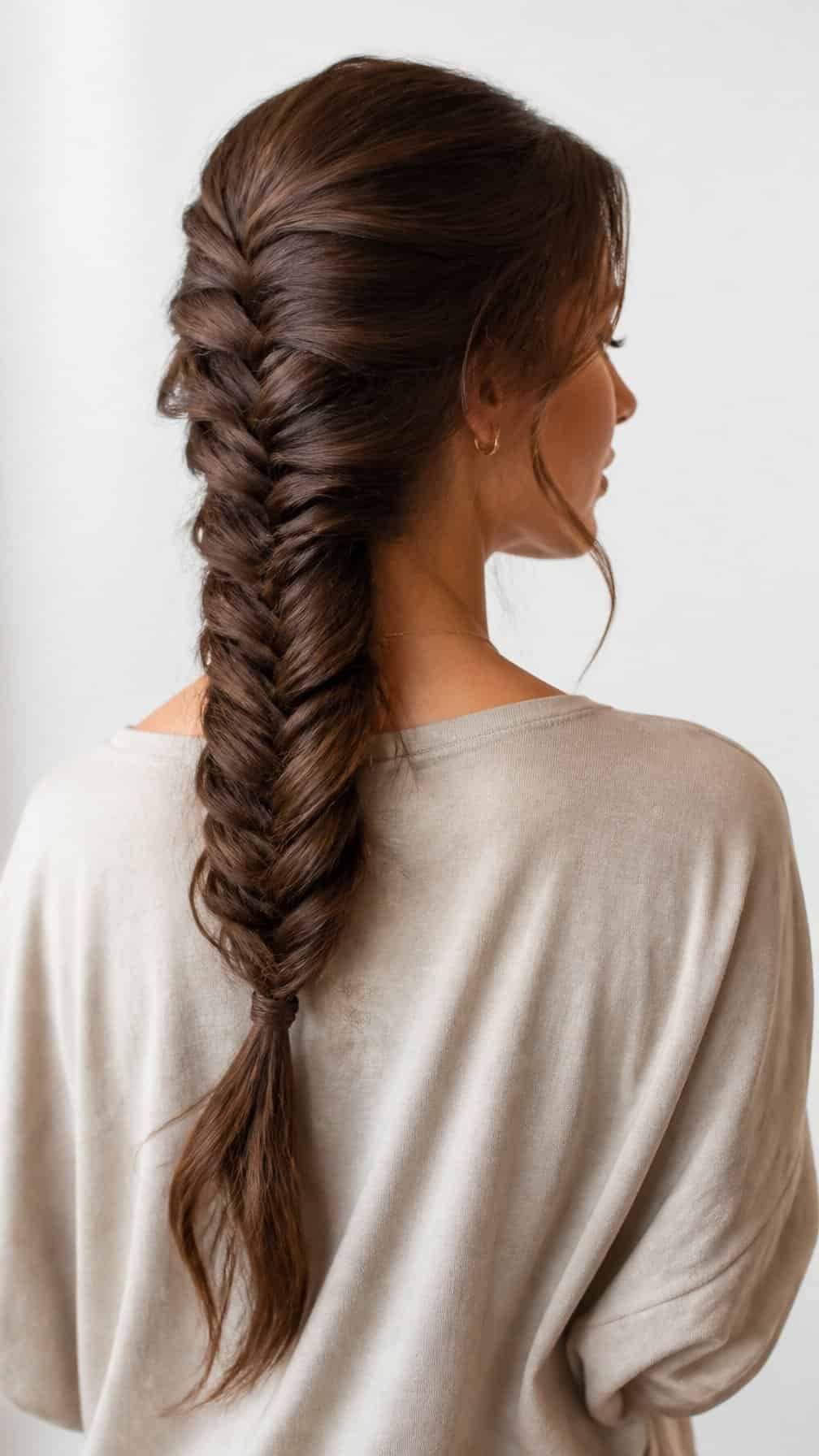 Woman with long hair styled in a fishtail braid down her back.