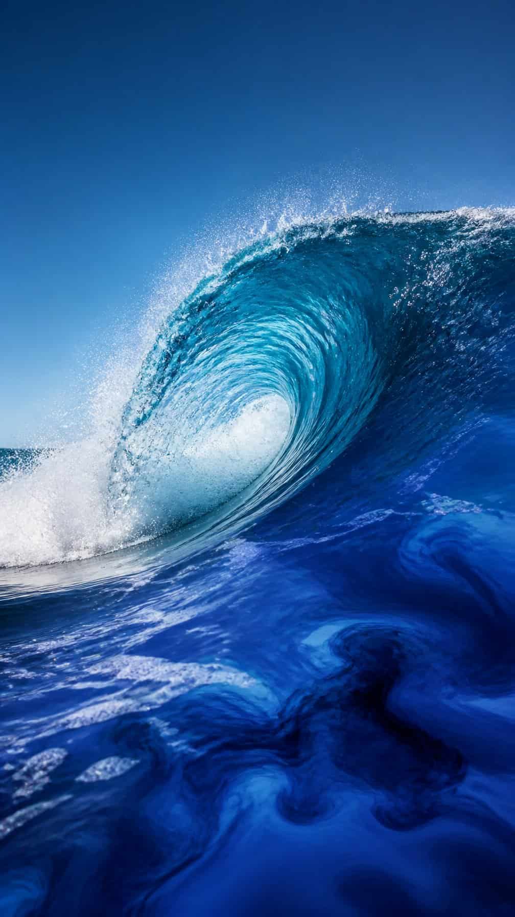 A curling ocean wave rises above swirling blue ink.