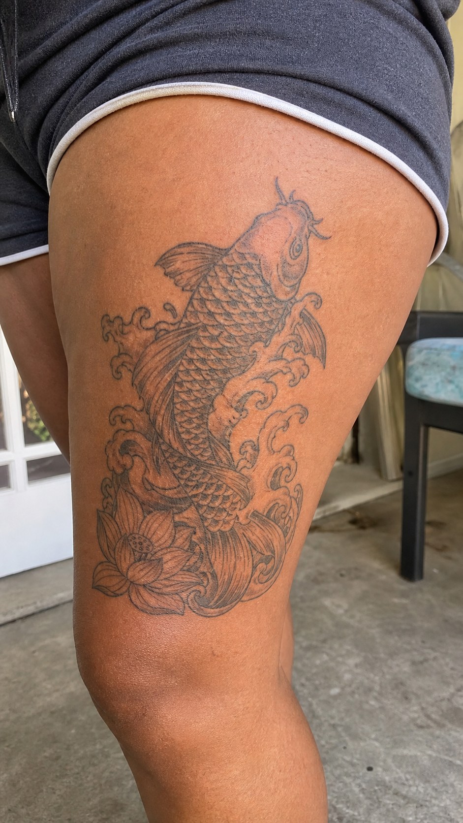 Empowering and Beautiful: 23 Japanese Tattoos for the Modern Woman 3 Healed the enchanting koi fish tattoo on a adult woman's outer thigh, photographed in a natural casual close three-quarter view — study 2