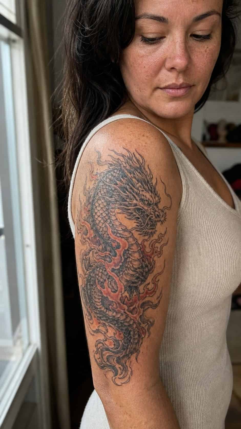 Empowering and Beautiful: 23 Japanese Tattoos for the Modern Woman 7 Healed fiery dragon majesty tattoo on a adult woman's outer upper arm, photographed in a natural slightly elevated close view — study 2