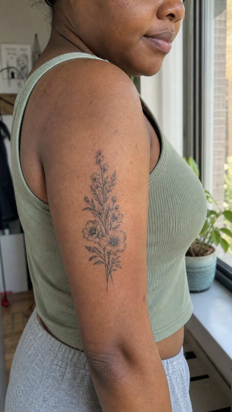 38 Creative Tattoo Ideas for Women 2 Healed delicate floral arrangement tattoo on a adult woman's outer upper arm, photographed in a natural relaxed documentary crop — study 1