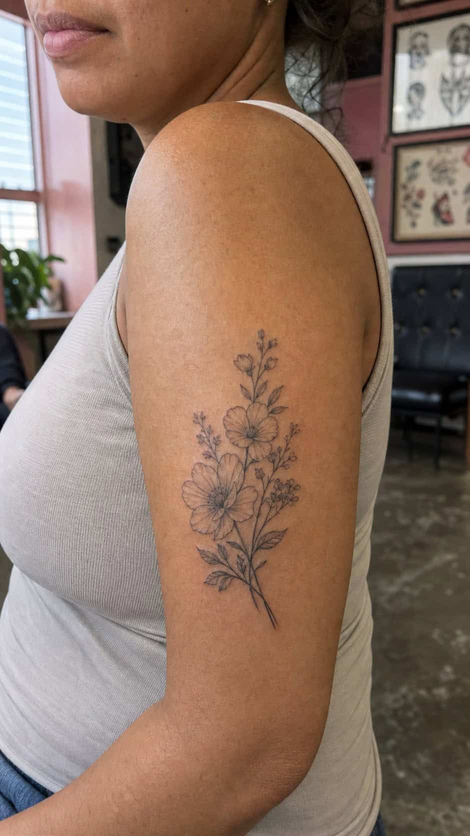 38 Creative Tattoo Ideas for Women 3 Healed delicate floral arrangement tattoo on a adult woman's outer upper arm, photographed in a natural casual close three-quarter view — study 2