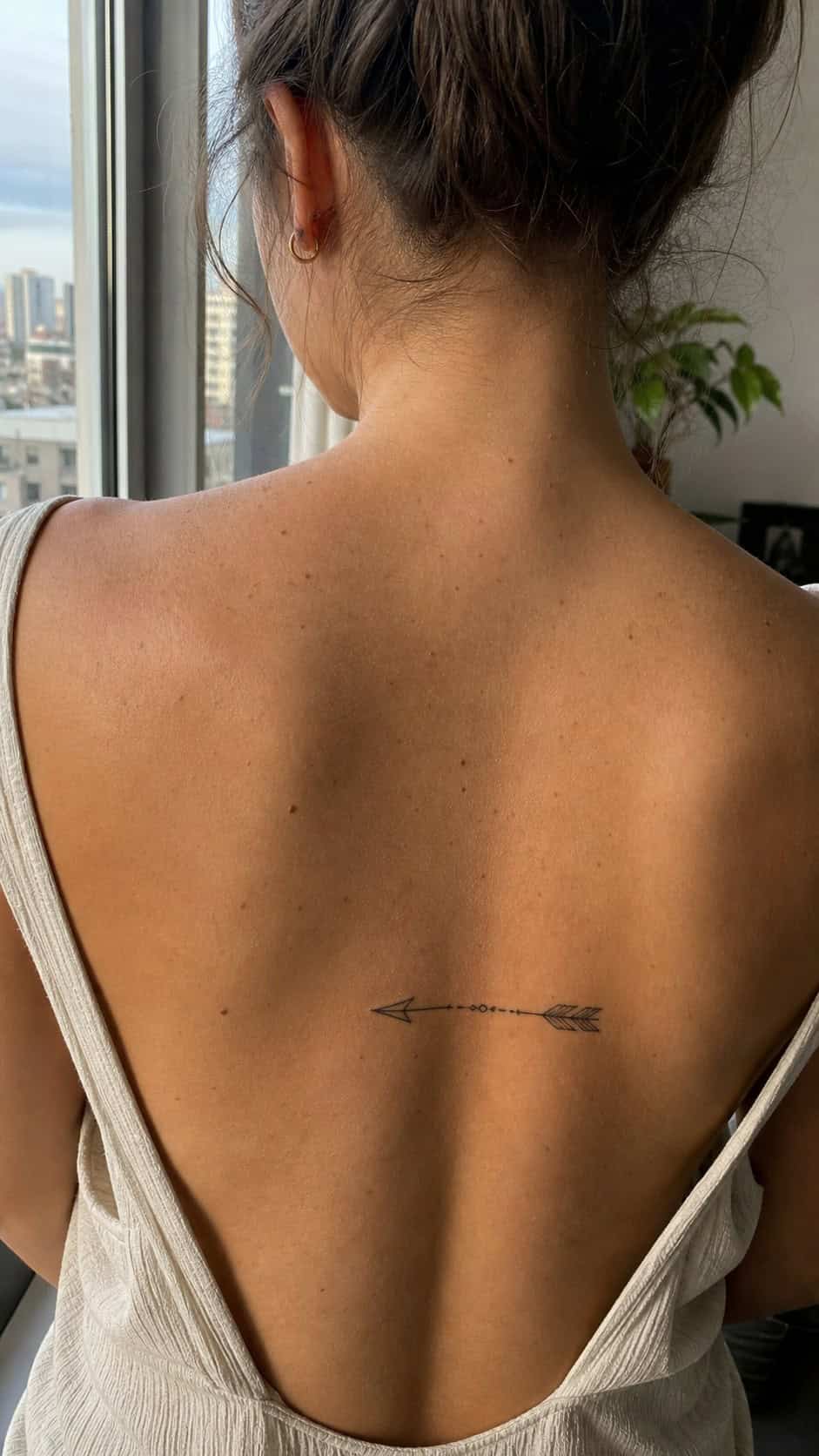 38 Creative Tattoo Ideas for Women 11 Healed minimalist arrow tattoo on a adult woman's upper back, photographed in a natural slightly elevated close view — study 1
