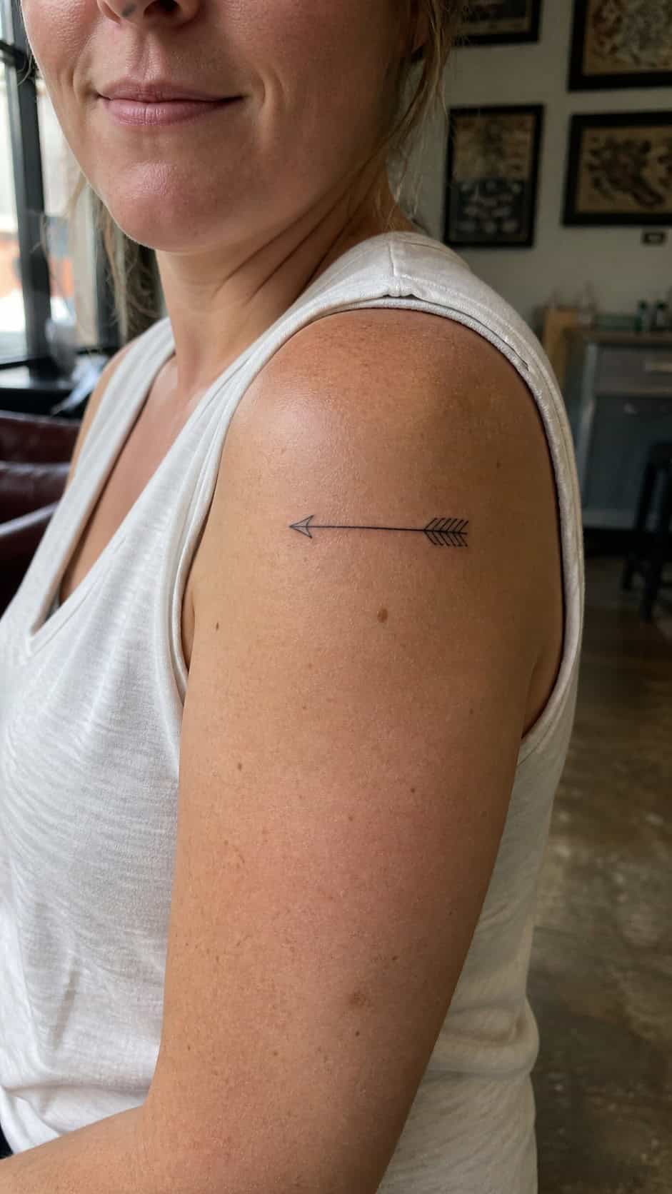 38 Creative Tattoo Ideas for Women 12 Healed minimalist arrow tattoo on a adult woman's shoulder, photographed in a natural waist-height candid close-up — study 2