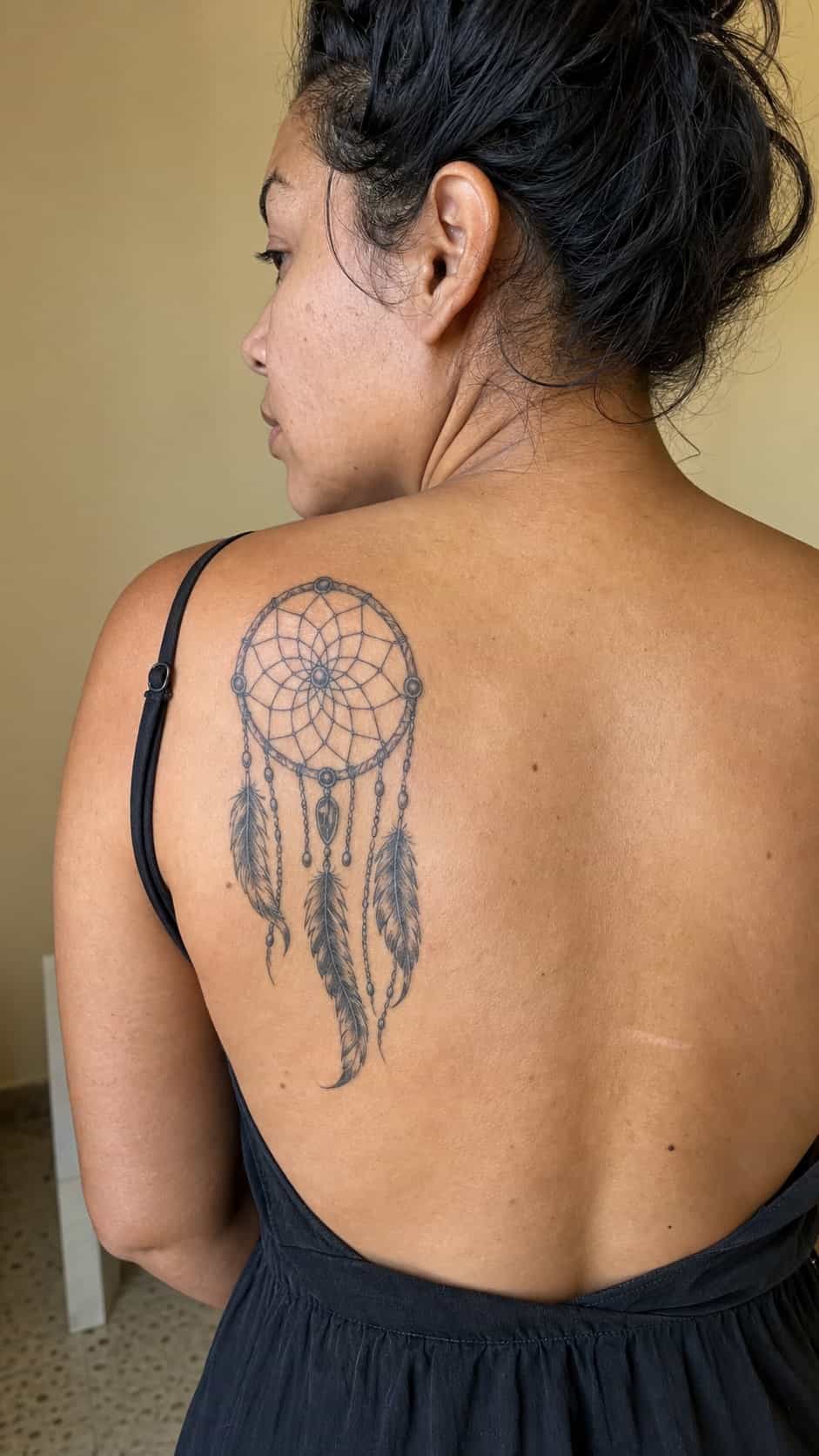 38 Creative Tattoo Ideas for Women 13 Healed dreamcatcher tattoo on a adult woman's upper back, photographed in a natural casual close three-quarter view — study 1