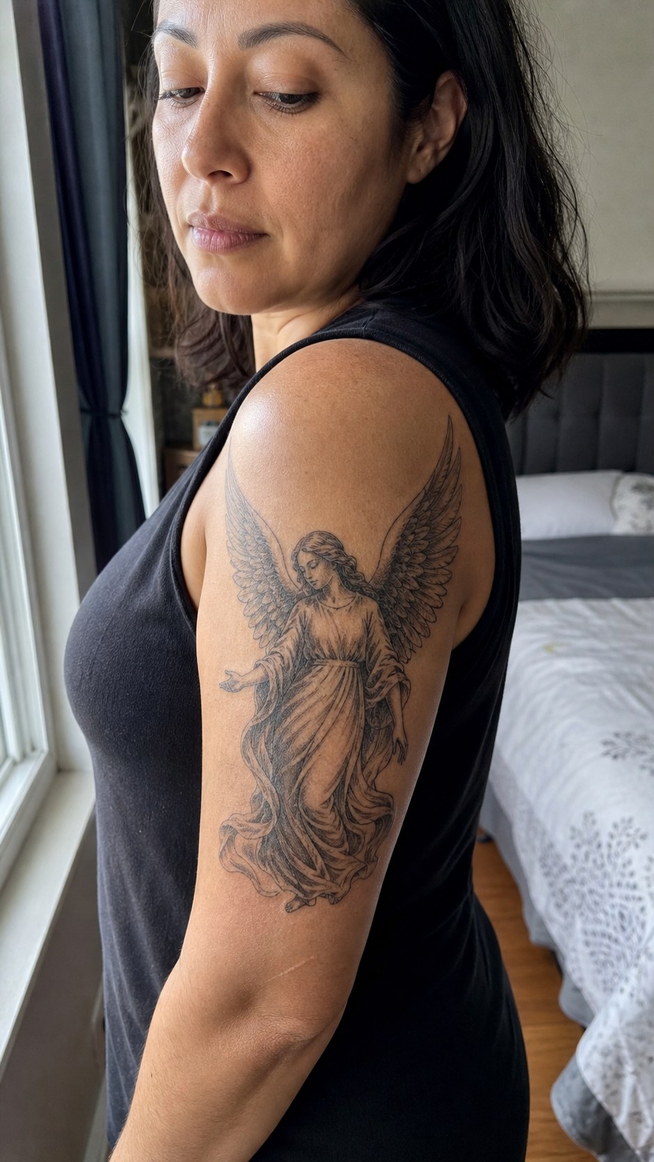 38 Creative Tattoo Ideas for Women 27 Healed winged angel tattoo on a adult woman's outer upper arm, photographed in a natural slightly elevated close view — study 2