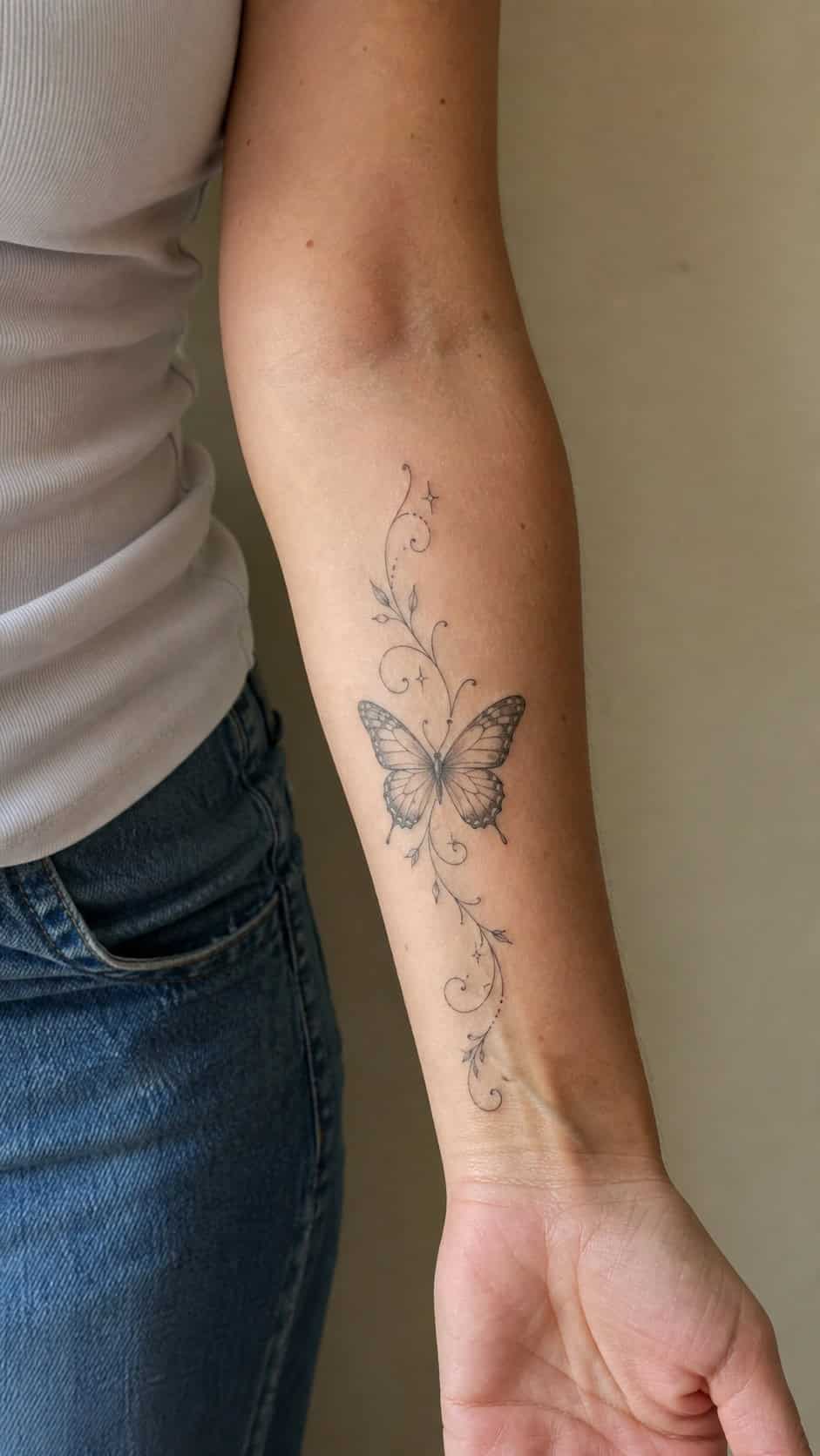 Healed whimsical butterfly design tattoo on a adult woman's inner forearm, photographed in a natural slightly elevated close view — study 2