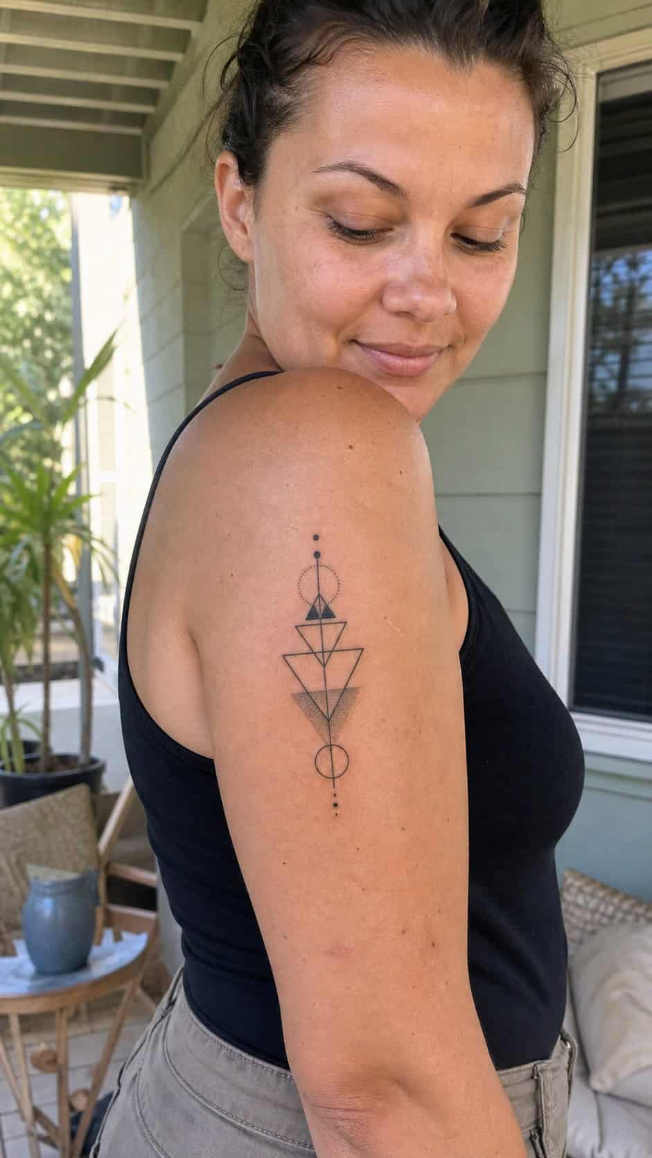 Healed geometric minimalism tattoo on a adult woman's outer upper arm, photographed in a natural gentle side angle that clearly shows — study 2