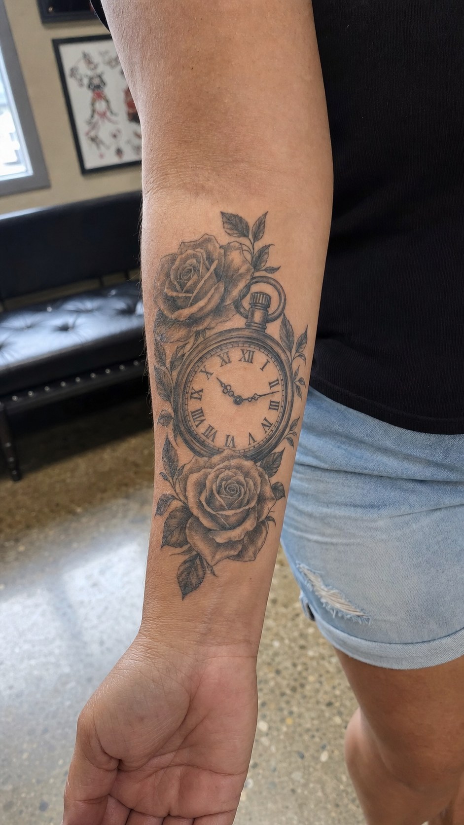 Healed timeless clock and roses tattoo on a adult woman's inner forearm, photographed in a natural relaxed documentary crop — study 2