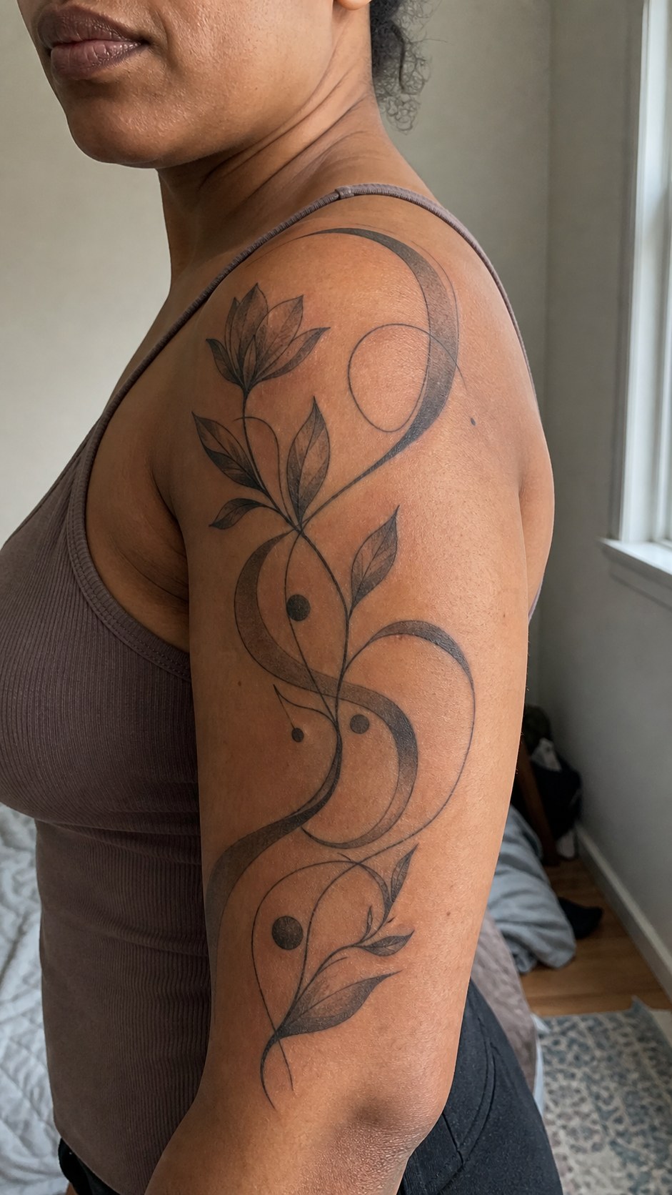 Healed surreal abstract art tattoo on a adult woman's shoulder, photographed in a natural slightly elevated close view — study 2