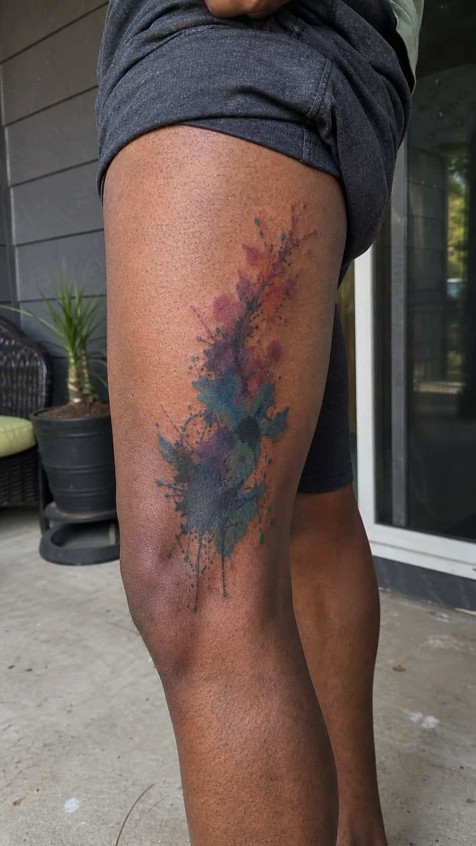 Feeling Bold? Try These 25 Killer Thigh Tattoo Ideas for Men 20 Healed abstract watercolor splash tattoo on a adult man's outer thigh, photographed in a natural gentle side angle that clearly shows — study 2