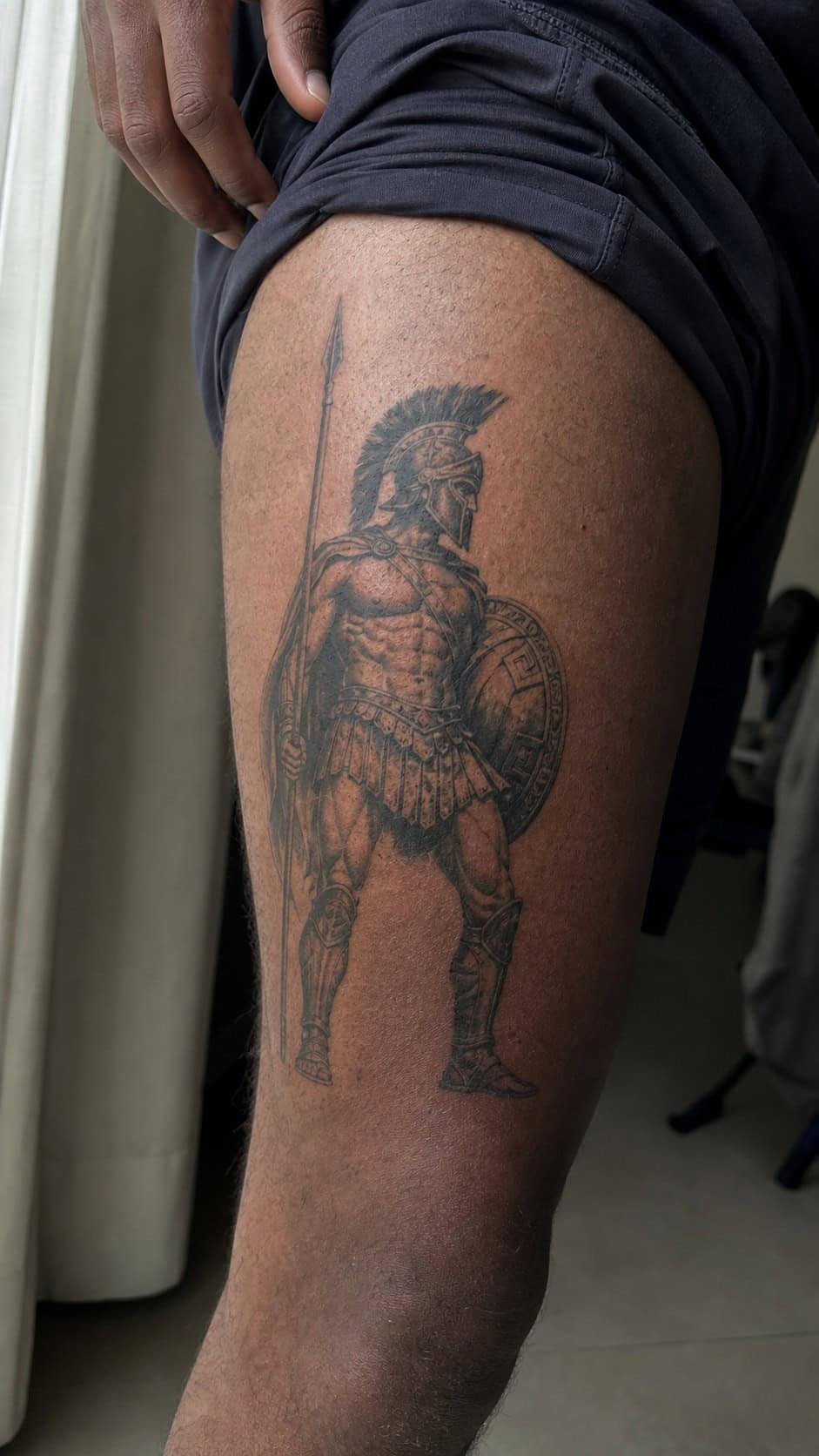 Feeling Bold? Try These 25 Killer Thigh Tattoo Ideas for Men 25 Healed ancient greek warrior tattoo on a adult man's outer thigh, photographed in a natural slightly elevated close view — study 1