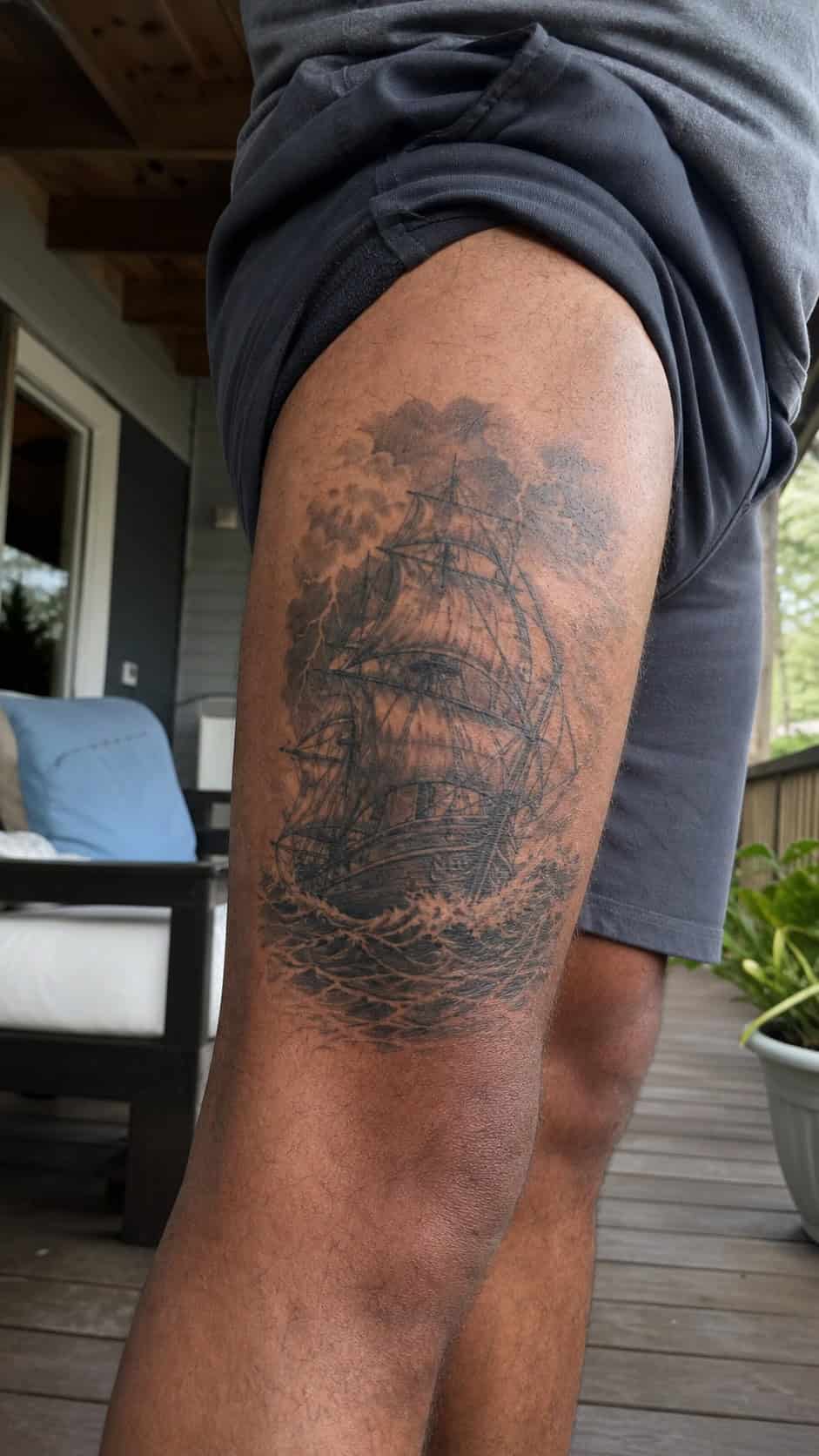 Feeling Bold? Try These 25 Killer Thigh Tattoo Ideas for Men 34 Healed pirate ship in stormy seas tattoo on a adult man's outer thigh, photographed in a natural casual close three-quarter view — study 2