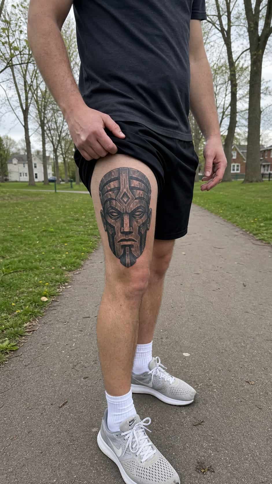Feeling Bold? Try These 25 Killer Thigh Tattoo Ideas for Men 35 Healed tribal warrior mask tattoo on a adult man's side ribs, photographed in a natural slightly elevated close view — study 1