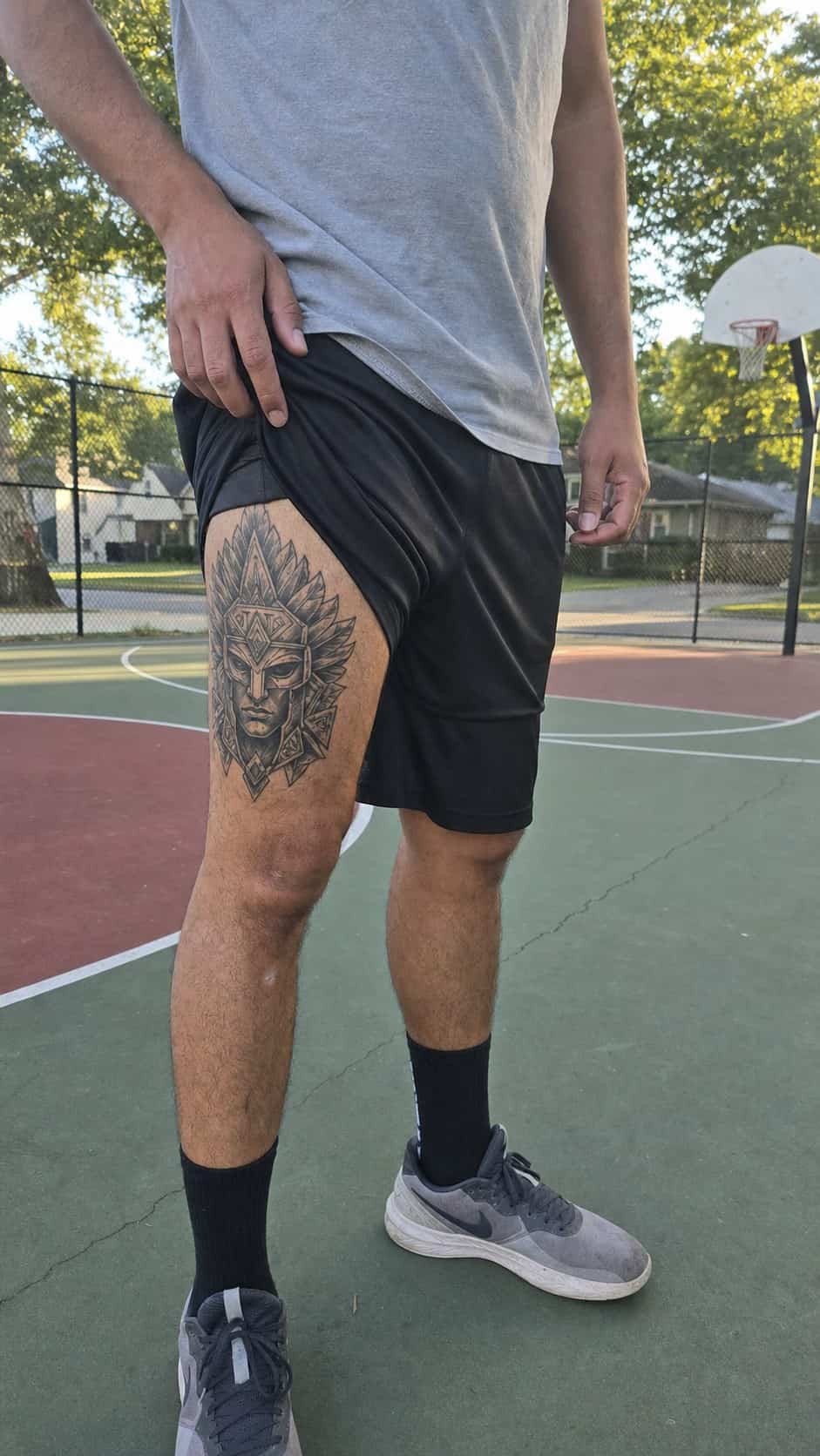 Feeling Bold? Try These 25 Killer Thigh Tattoo Ideas for Men 36 Healed tribal warrior mask tattoo on a adult man's side ribs, photographed in a natural waist-height candid close-up — study 2