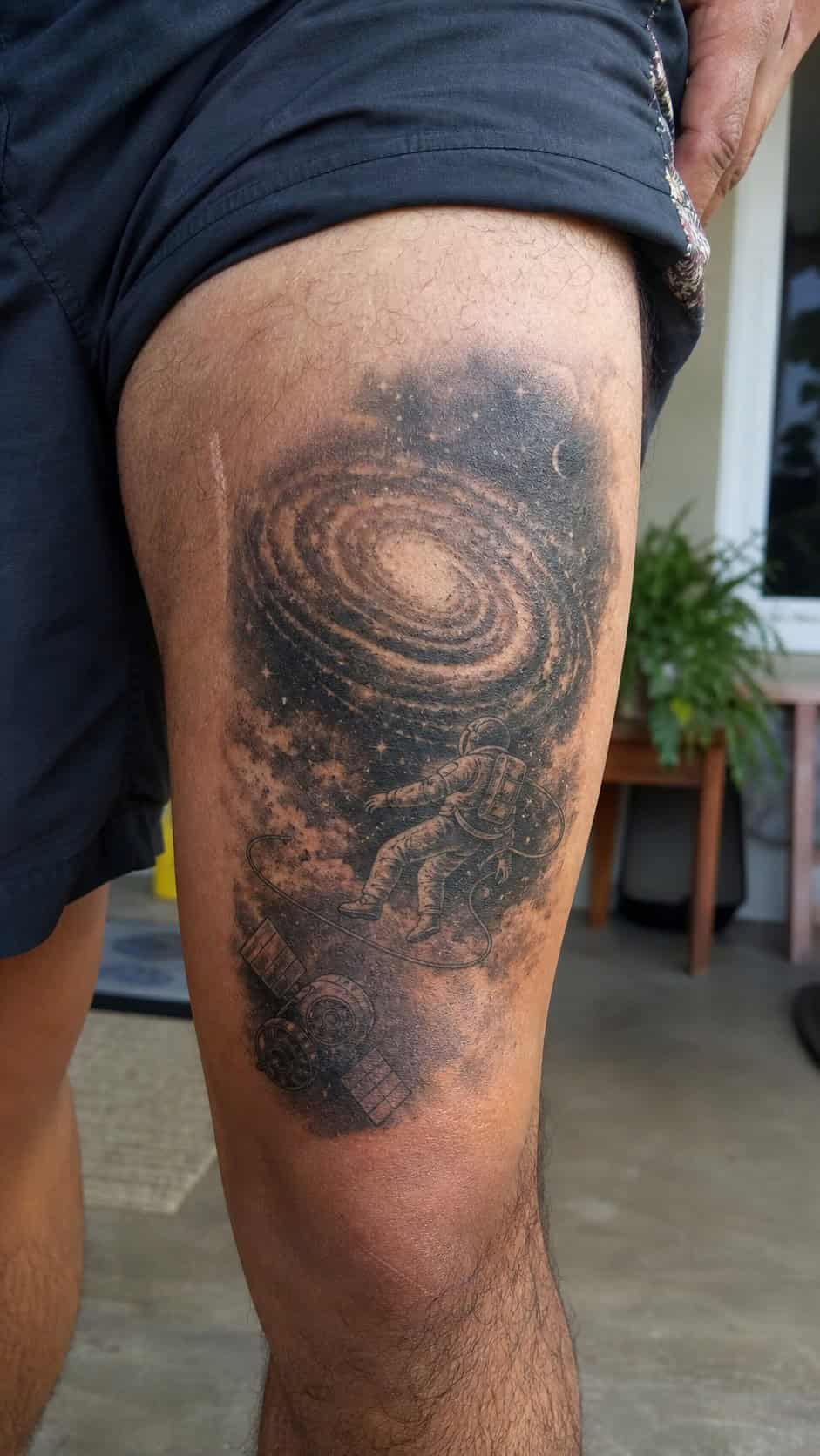 Feeling Bold? Try These 25 Killer Thigh Tattoo Ideas for Men 37 Healed galaxy and space exploration tattoo on a adult man's outer thigh, photographed in a natural relaxed documentary crop — study 1