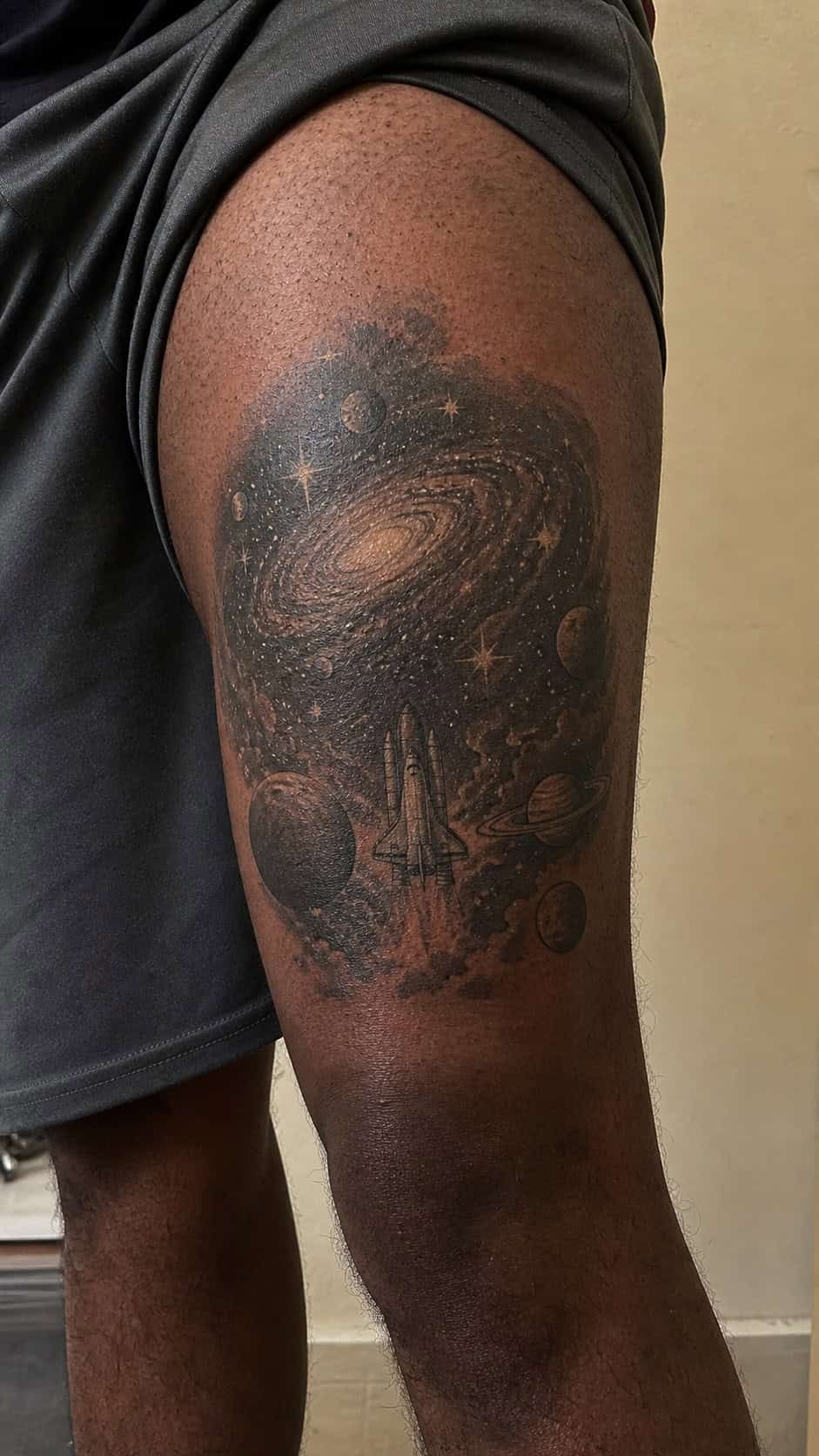 Feeling Bold? Try These 25 Killer Thigh Tattoo Ideas for Men 38 Healed galaxy and space exploration tattoo on a adult man's outer thigh, photographed in a natural casual close three-quarter view — study 2