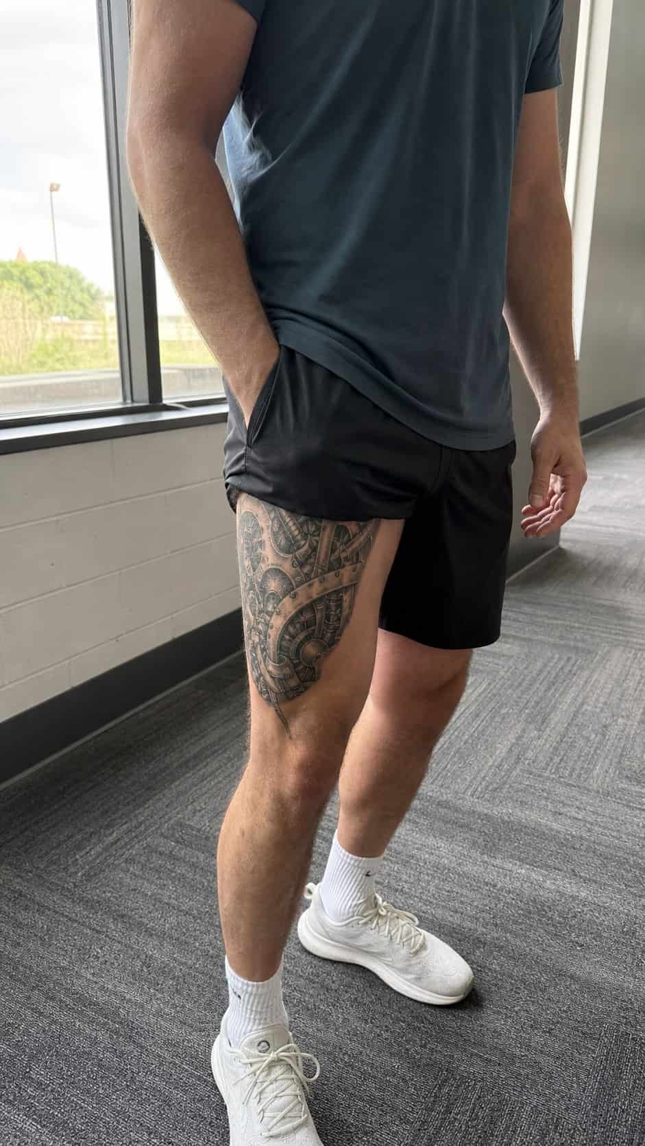 Feeling Bold? Try These 25 Killer Thigh Tattoo Ideas for Men 44 Healed biomechanical fusion tattoo on a adult man's outer thigh, photographed in a natural waist-height candid close-up — study 1