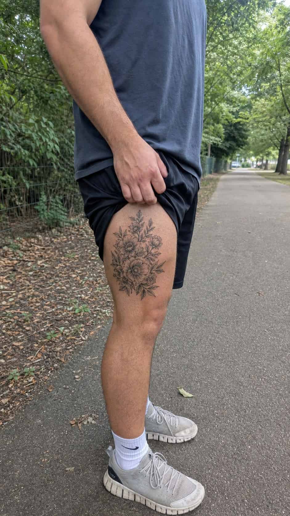 Feeling Bold? Try These 25 Killer Thigh Tattoo Ideas for Men 50 Healed detailed floral arrangement tattoo on a adult man's outer thigh, photographed in a natural casual close three-quarter view — study 2